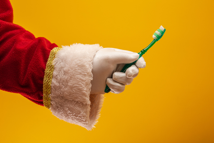 Santa Clause holding a toothbrush.