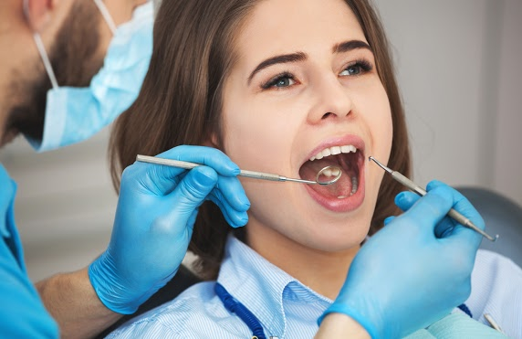 young woman receives dental exam